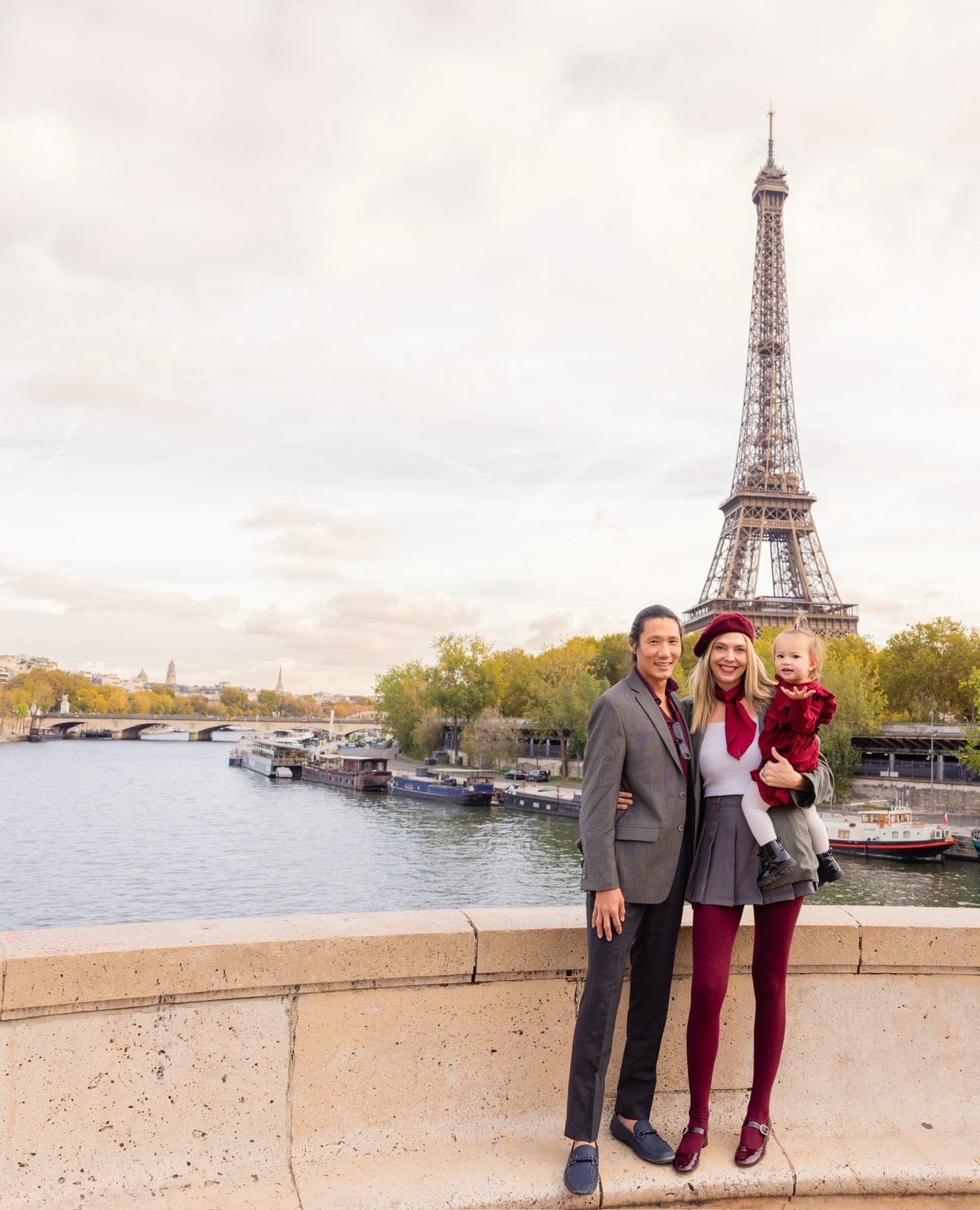 Alexandra and her family on a bridge over the Seine with the Eiffel Tower behind them