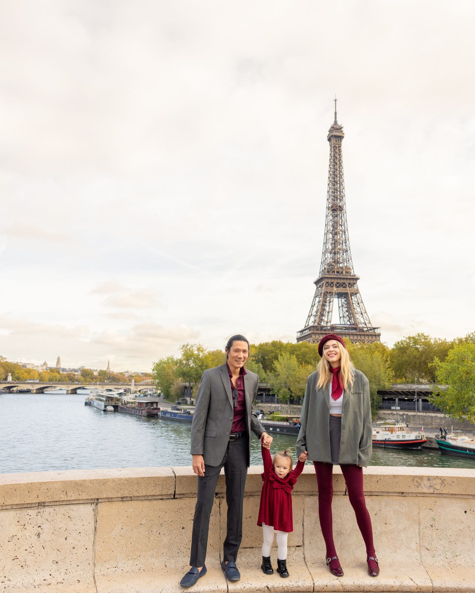 Alexandra and her family standing by the Seine with the Eiffel Tower in the distance
